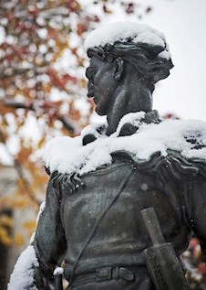 Mountaineer Statute with Snow on its shoulders