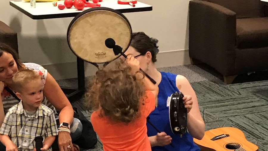 Children learning how to play drums and guitars.