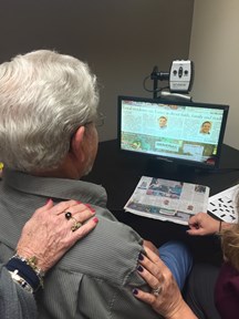 Adult patient reads a screen during a low vision evaluation