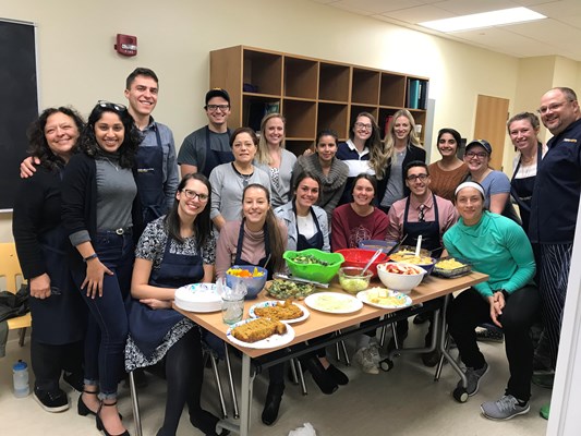 CLMT students and faculty pose with a freshly prepared meal
