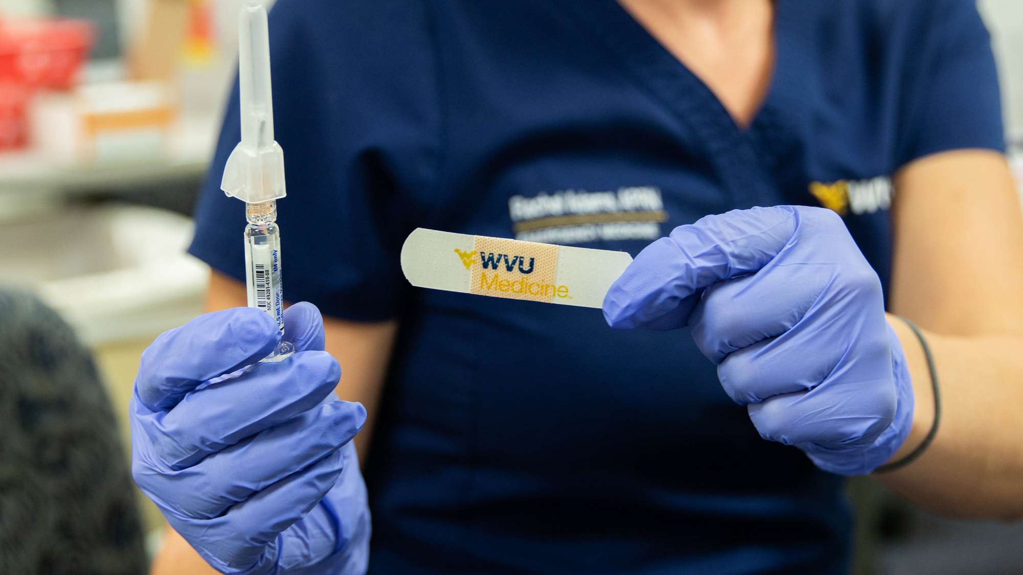 Photo of WVU Medicine nurse holding syringe and bandage