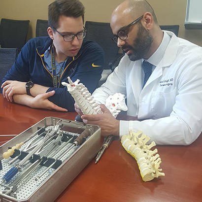Rahul Singh (R) discusses spinal techniques with Jesse Lawrence (L)