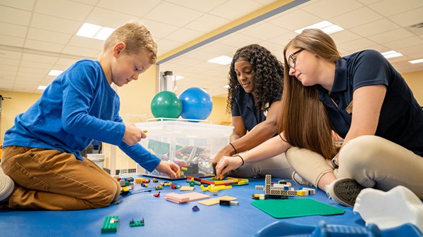 Students work with a patient in the OT lab.