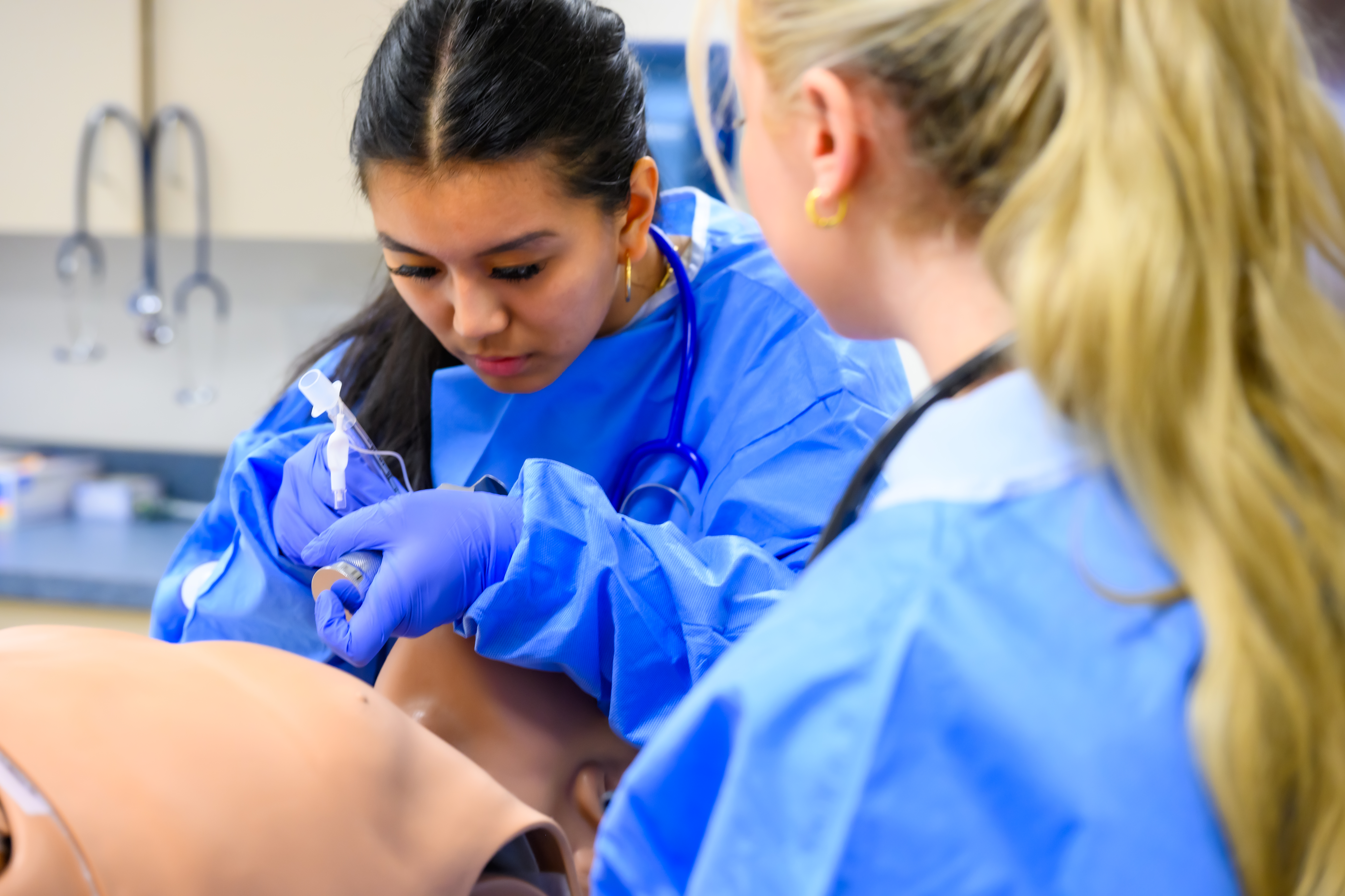 Two students practice intubating a manikin
