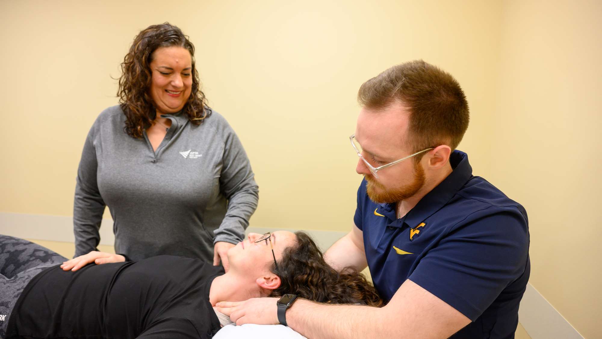 Faculty oversees student performing therapy with patient