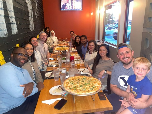 Residents with their families enjoying a meal at Pies and Pints at a long table.