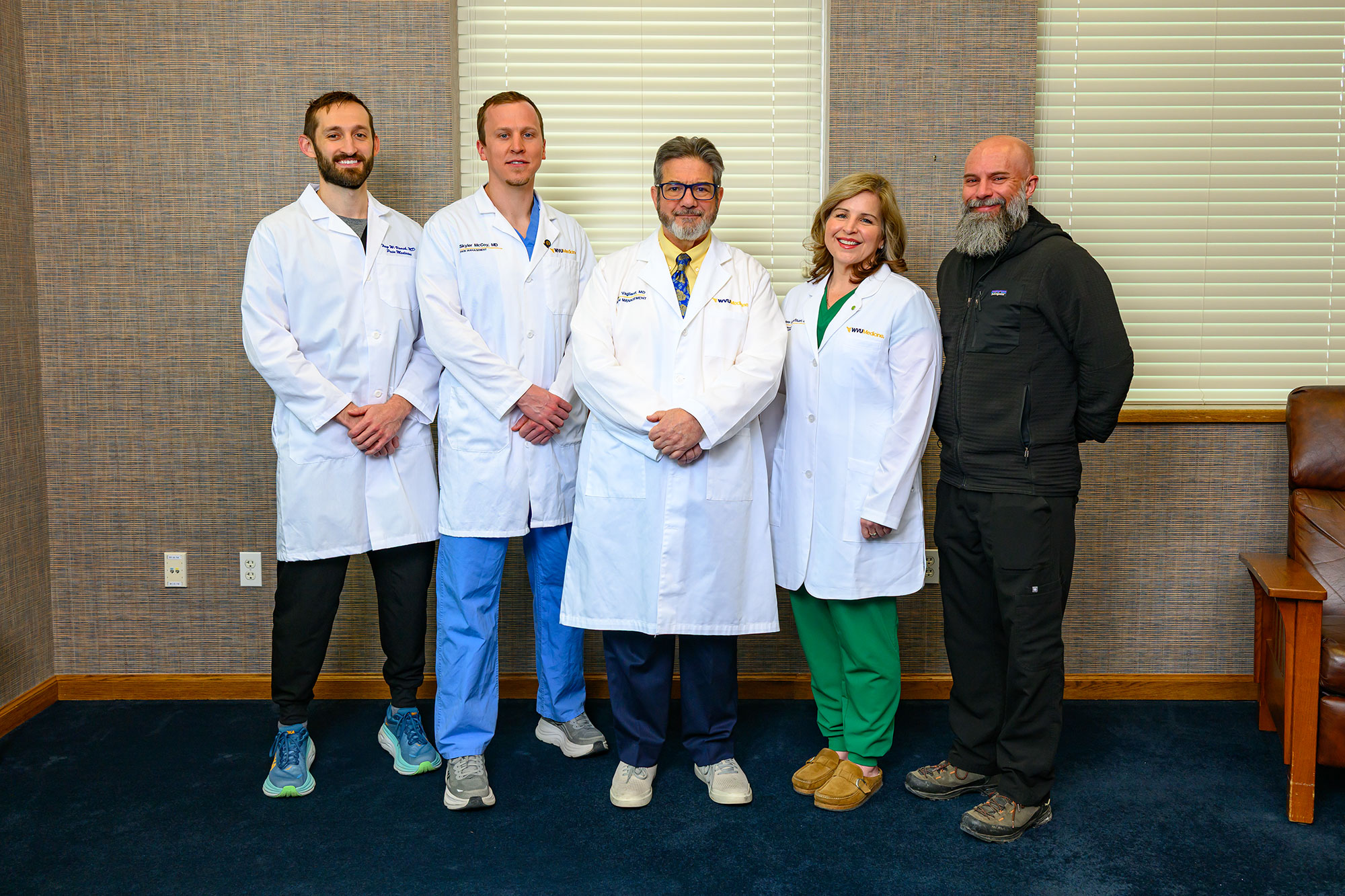 A picture of the pain fellowship faculty in a waiting area next to windows.