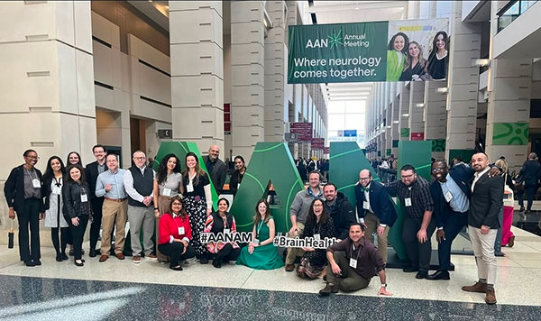Residents gathering at the AAN Annual meeting. They are in the main hall gathering around the large three dimensional letters staged for the event in different poses.