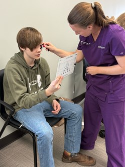 Photo of a CVRP student receiving a screening from the WVU Eye Institute specialist